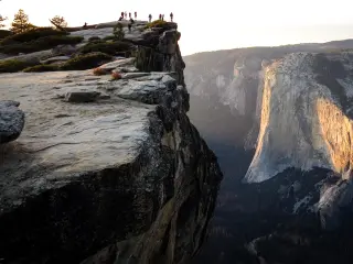 Distance view of hikers at the summit Taft Point at Yosemite National Park