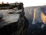 Distance view of hikers at the summit Taft Point at Yosemite National Park