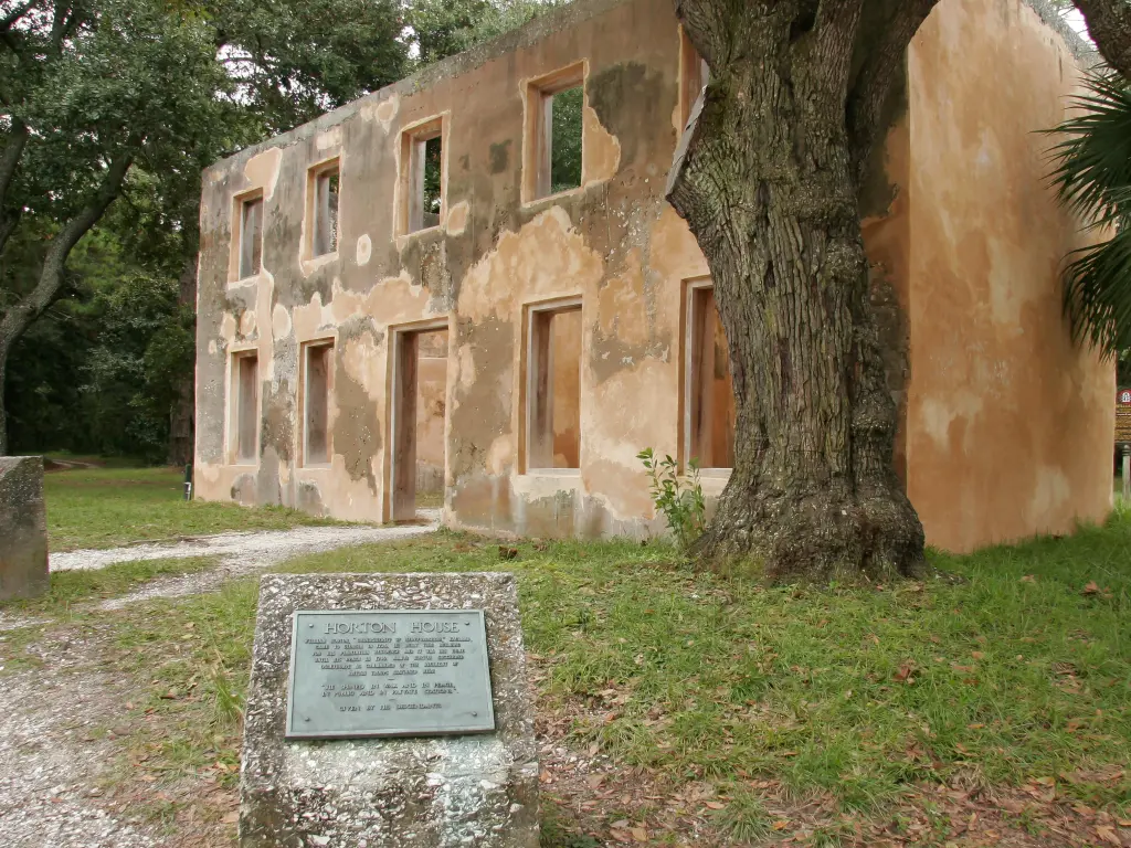 The pink colored ruins of the oldest house in Georgia, with a plaque explaining its history in view