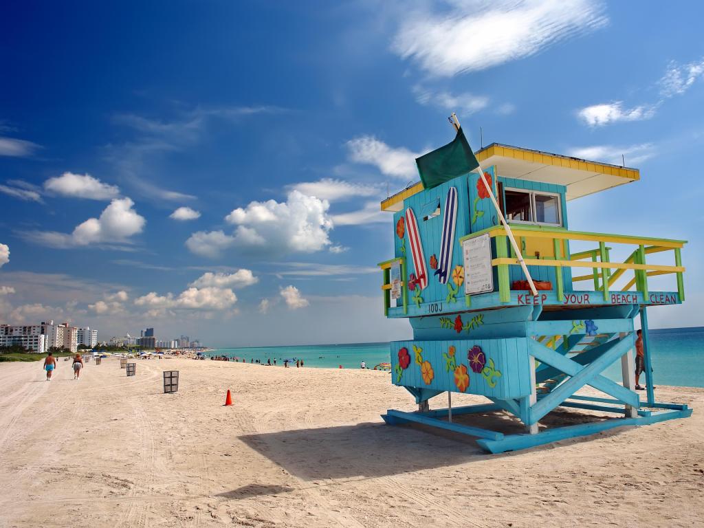 South Beach Miami, Florida, USA with a beach hut in the foreground and a blue sky, sand and sea in the distance. 