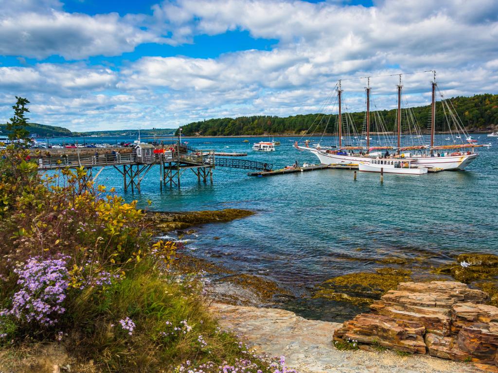 Rocky coast and view of boats in the harbor at Bar Harbor