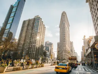 Flat Iron building facade, with NYC Fifth Avenue and taxi cabs