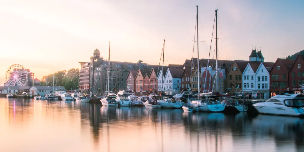 The sun reflecting on the water and boats floating in the harbour of Bergen in Norway