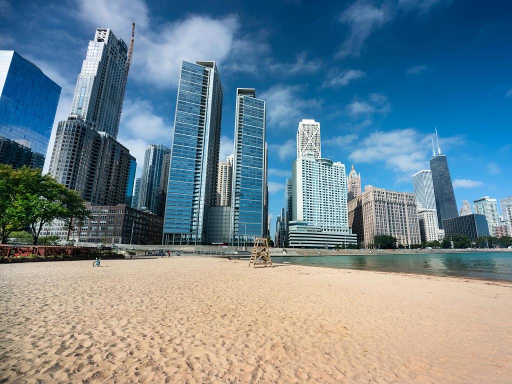 Lake Michigan, Illinois, USA with the Chicago cityscape across the sand of Ohio Street Beach on Lake Michigan and Lake Shore Drive on a sunny day.