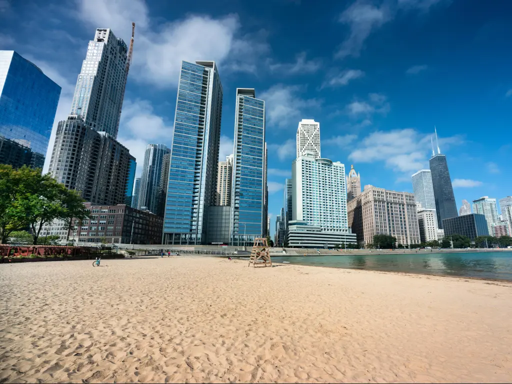 Lake Michigan, Illinois, USA with the Chicago cityscape across the sand of Ohio Street Beach on Lake Michigan and Lake Shore Drive on a sunny day.