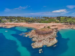 Aerial Drone image of Portelet Bay, Jersey, Channel Islands with blue sky and calm water.