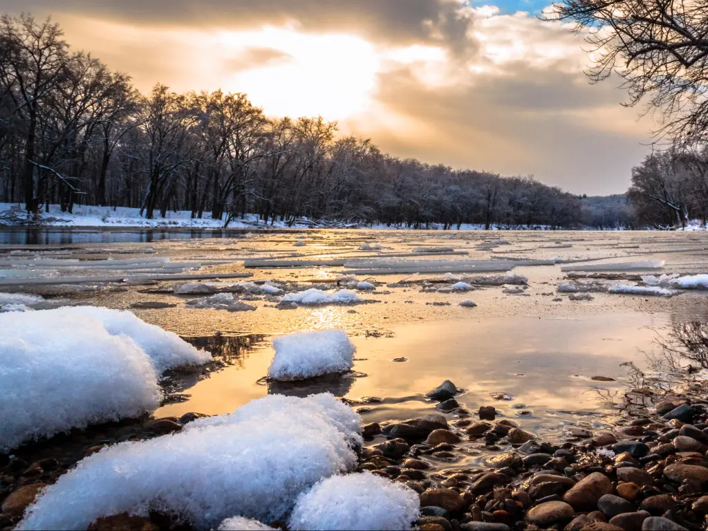 Winter River Sunset. Snow and ice float down the Grand River in Grand Rapids, Michigan, USA. 