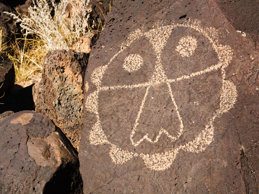 A symbol that looks like a face, carved on a rock