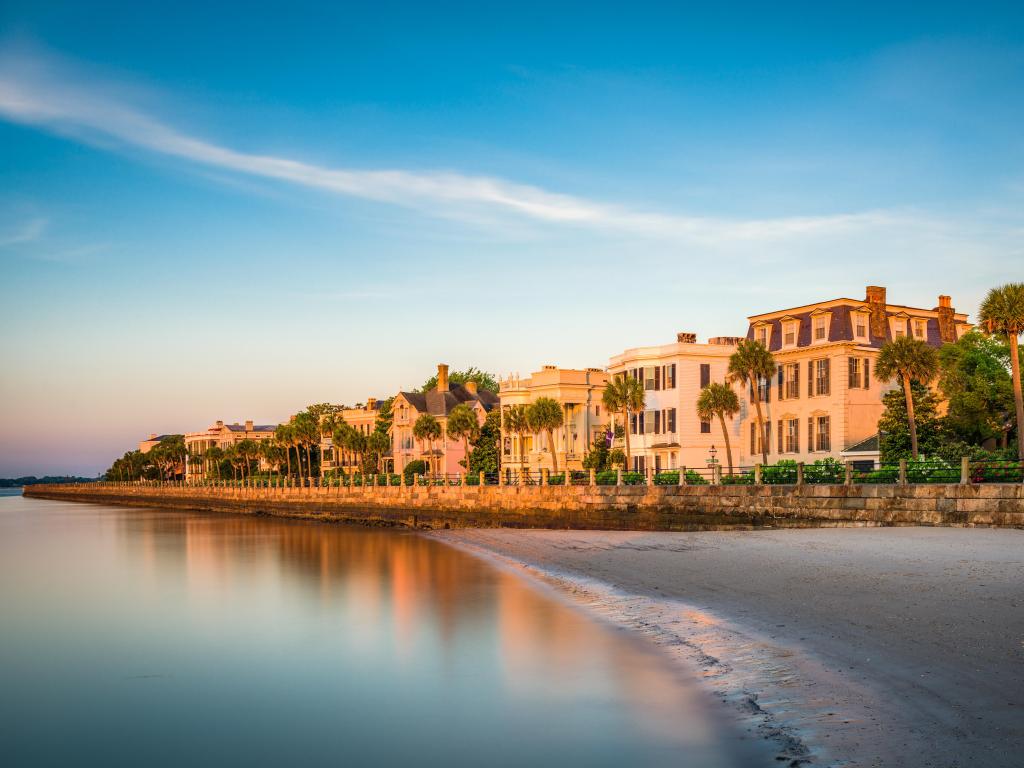 Charleston, South Carolina, USA homes along The Battery at sunset with the sea in the foreground. 