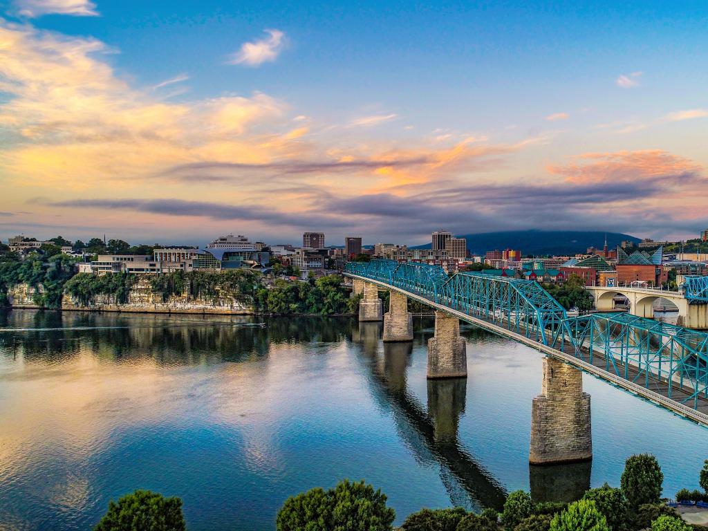 Chattanooga, Tennessee, USA with a drone aerial view of downtown Chattanooga and the Tennessee River at sunset.