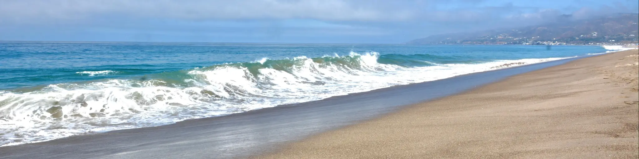 Sandy shores, rolling waves and blue skies across Zuma Beach