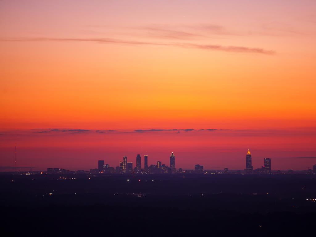 Atlanta skyline viewed from a distance from Stone Mountain in vibrant pink dusk sky