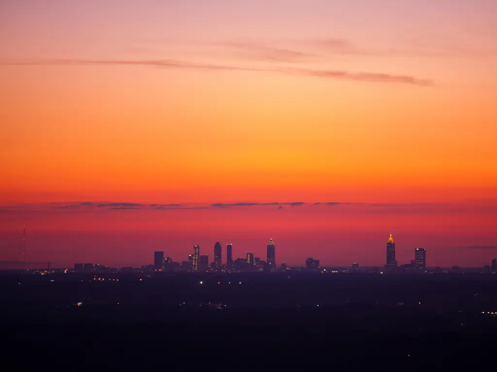 Atlanta skyline viewed from a distance from Stone Mountain in vibrant pink dusk sky
