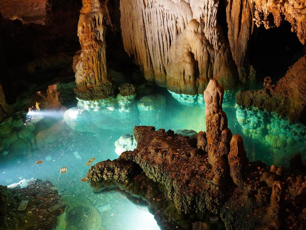 Luray Caverns, Virginia, USA taken at a wishing well with turquoise water, money floating and surrounded by rock formations.