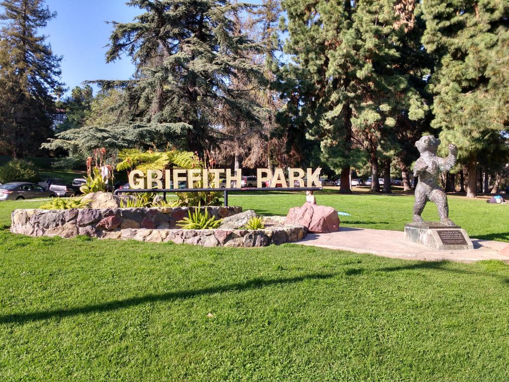 Griffith Park golden entrance sign and bear statue on a sunny day