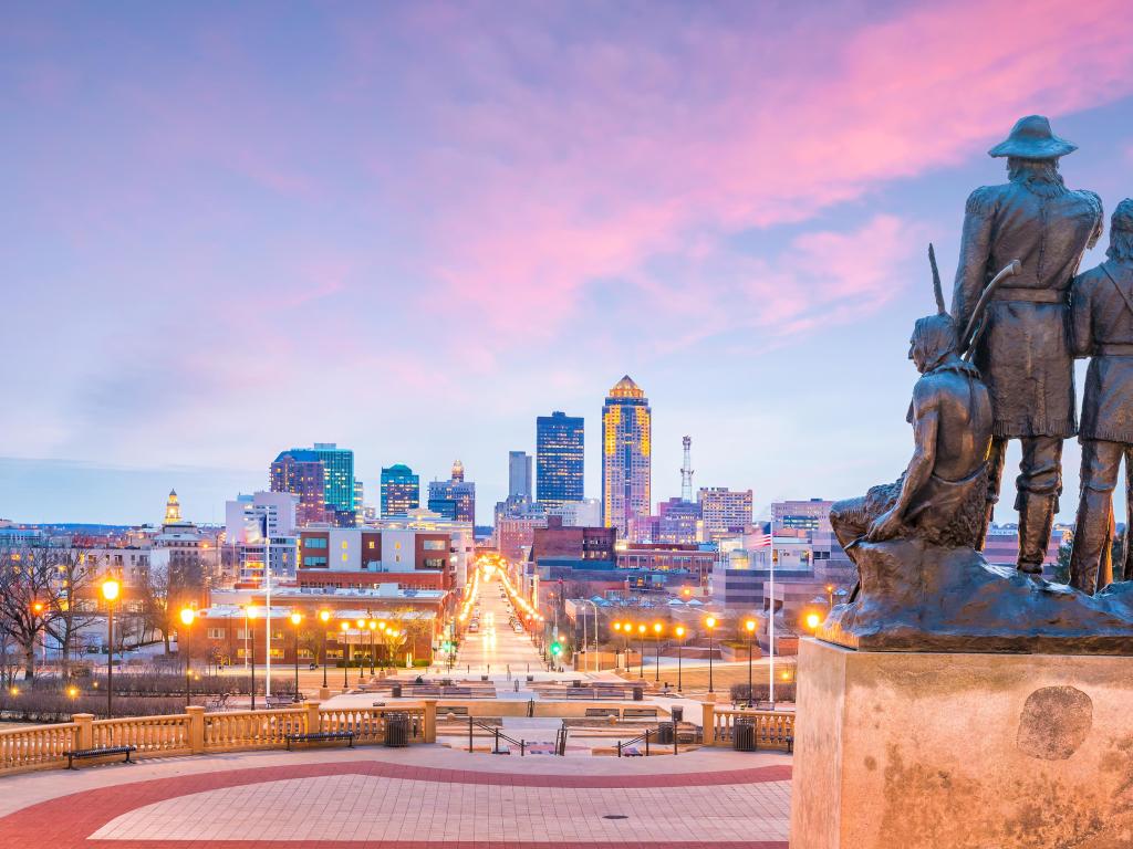 Des Moines, Iowa, USA skyline with The Pioneer of the former territory statue at sunset.