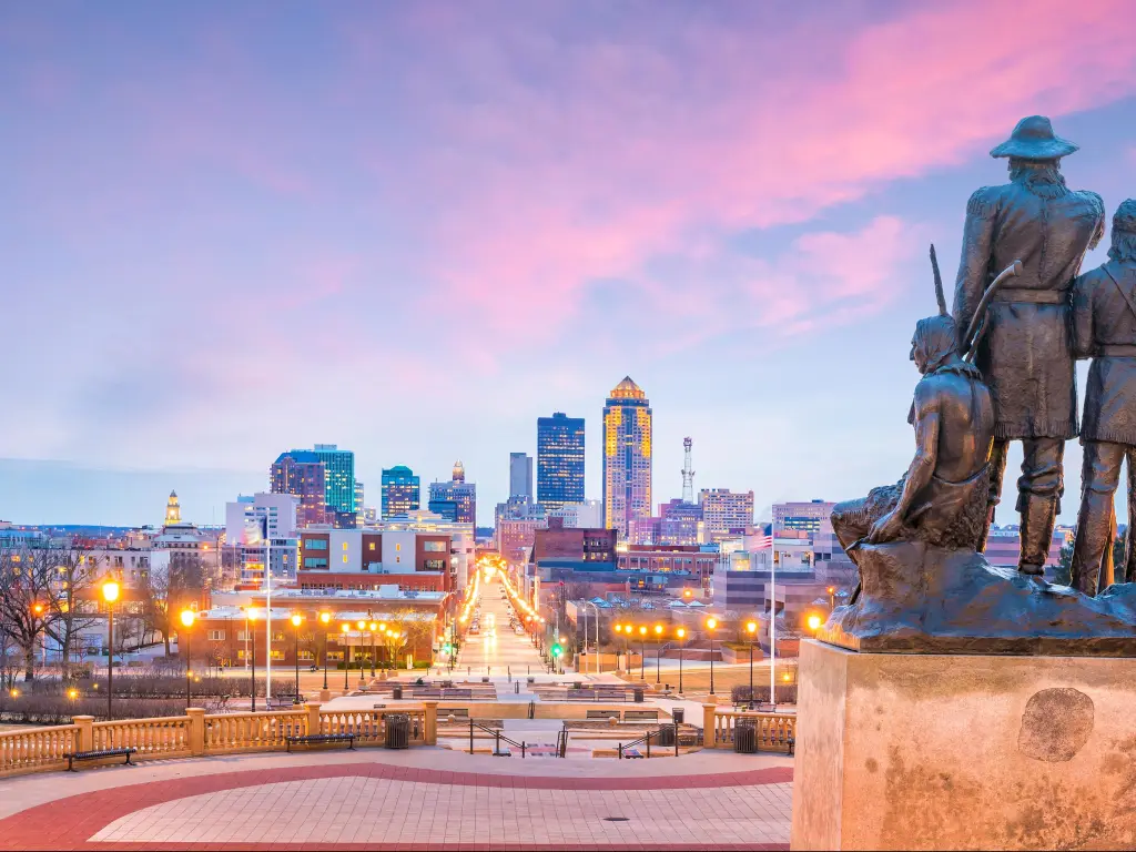 Des Moines, Iowa, USA skyline with The Pioneer of the former territory statue at sunset.