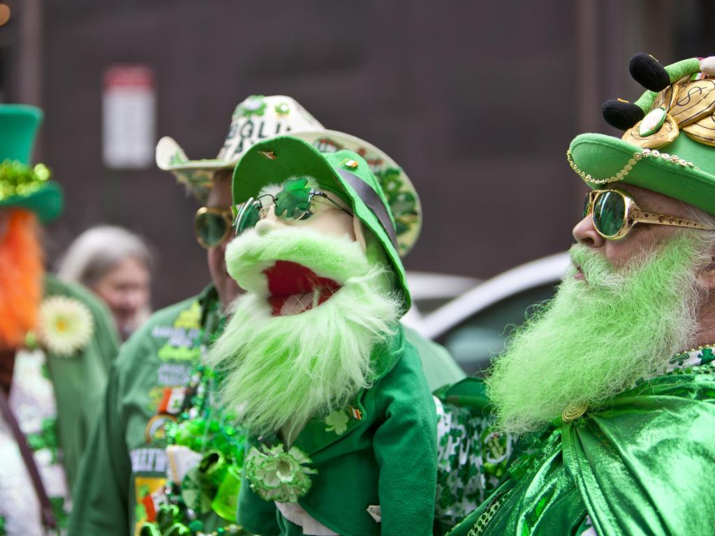 St Patrick's Day Parade participants, dressed in green traditional clothes, man holding up a puppet