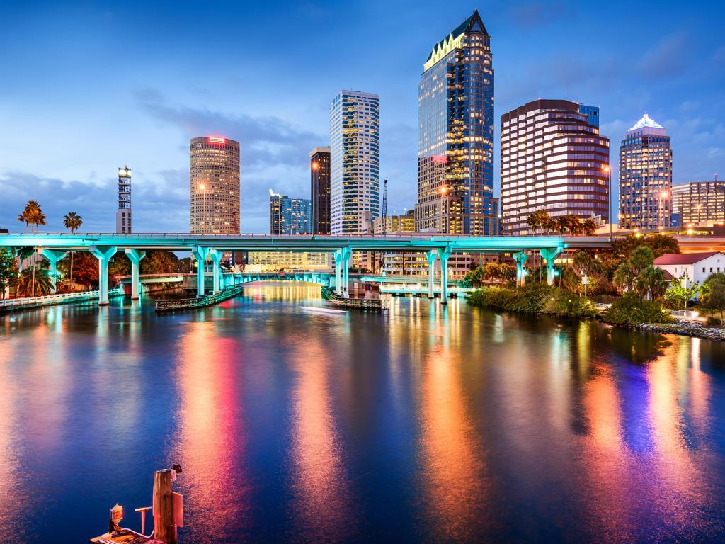 Tampa, Florida, USA downtown with the city skyline in the distance and the Hillsborough River in the foreground taken at night.