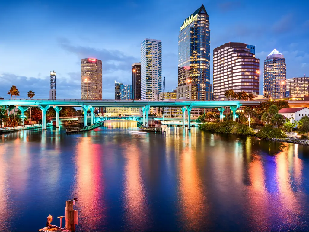 Tampa, Florida, USA downtown with the city skyline in the distance and the Hillsborough River in the foreground taken at night.