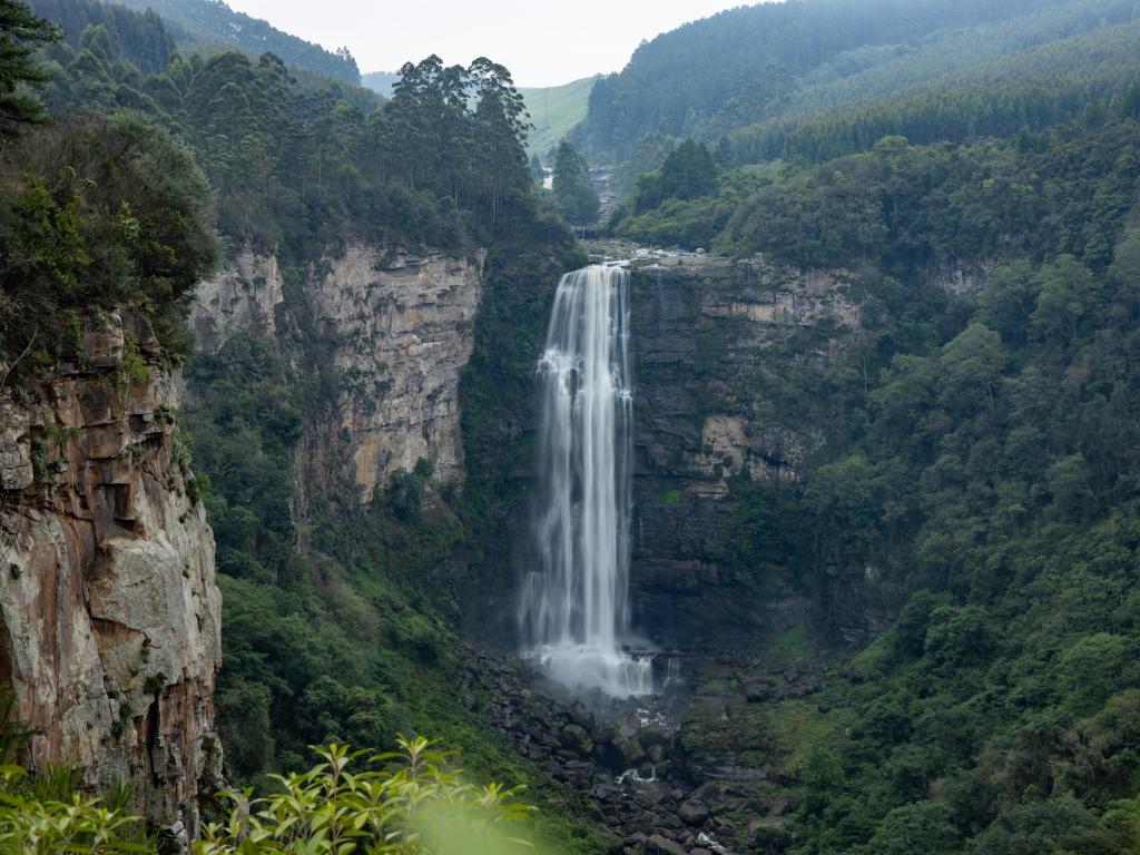 Karkloof Falls. Large Waterfall In a Lush Green Forest In Howick, South Africa. Surrounded By Mountain Cliffs, Trees and A Strong, Powerful Waterfall.