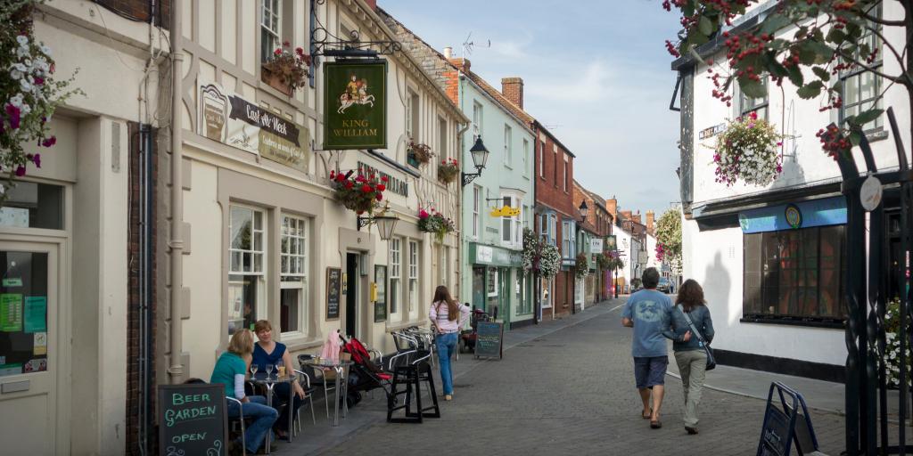 A couple strolling through the quaint streets of Glastonbury town in Somerset 