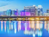 Orlando, Florida, USA downtown skyline panorama over Lake Eola at night with urban skyscrapers, fountain and clear sky.