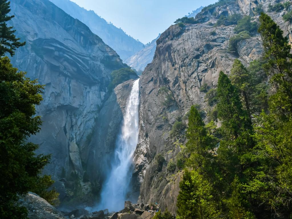 Water cascading down at Bridalviel Fall, Yosemite, with trees in the foreground