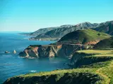 Big Sur, California, USA with a seascape view of the iconic Big Sur road alongside cliffs and the sea on a sunny day.