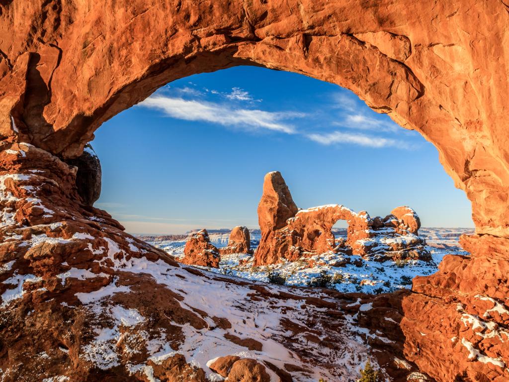 Dusting of snow on the red rocks of the North Window Arch and Turret Arch in Arches National Park, with a clear blue sky