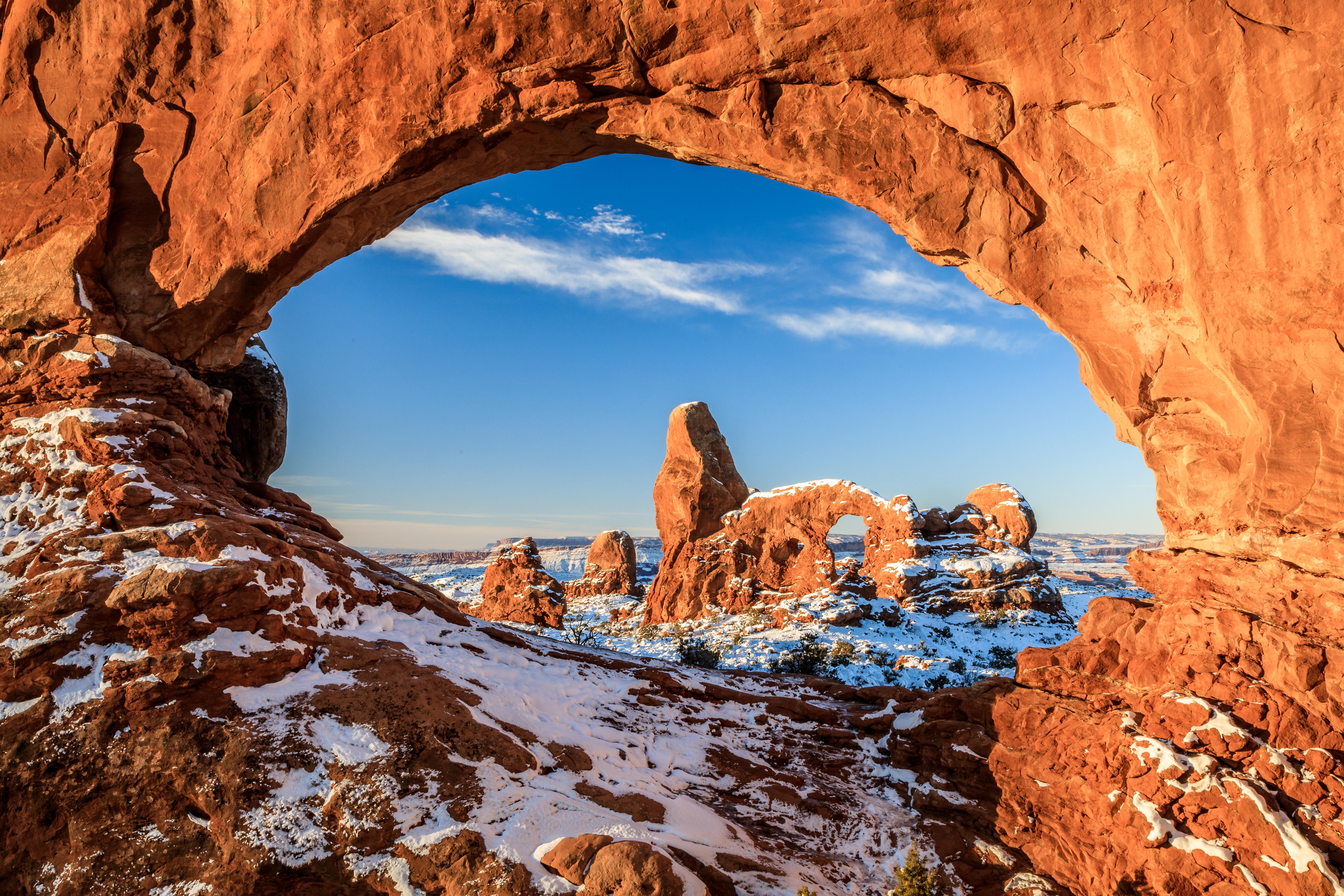 Dusting of snow on the red rocks of the North Window Arch and Turret Arch in Arches National Park, with a clear blue sky