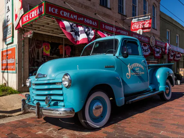 A blue classic chevy pickup outside the Jefferson General Store in Jefferson, Texas.