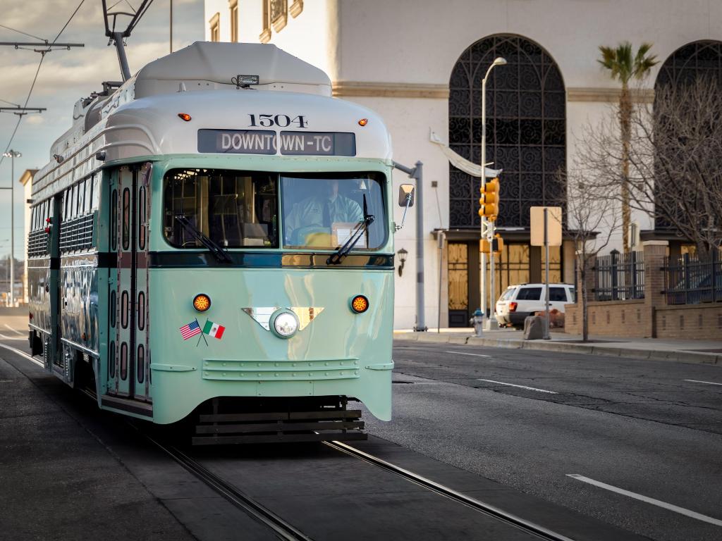 A turquoise and white vintage street car on the road in downtown El Paso, Texas