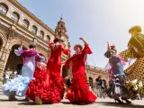 Flamenco dancers in Plaza España, Spain, two wearing red, the others in blue and pink dresses
