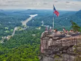 Chimney Rock overlooking Lake Lure, with American Flag standing proud in the foreground 