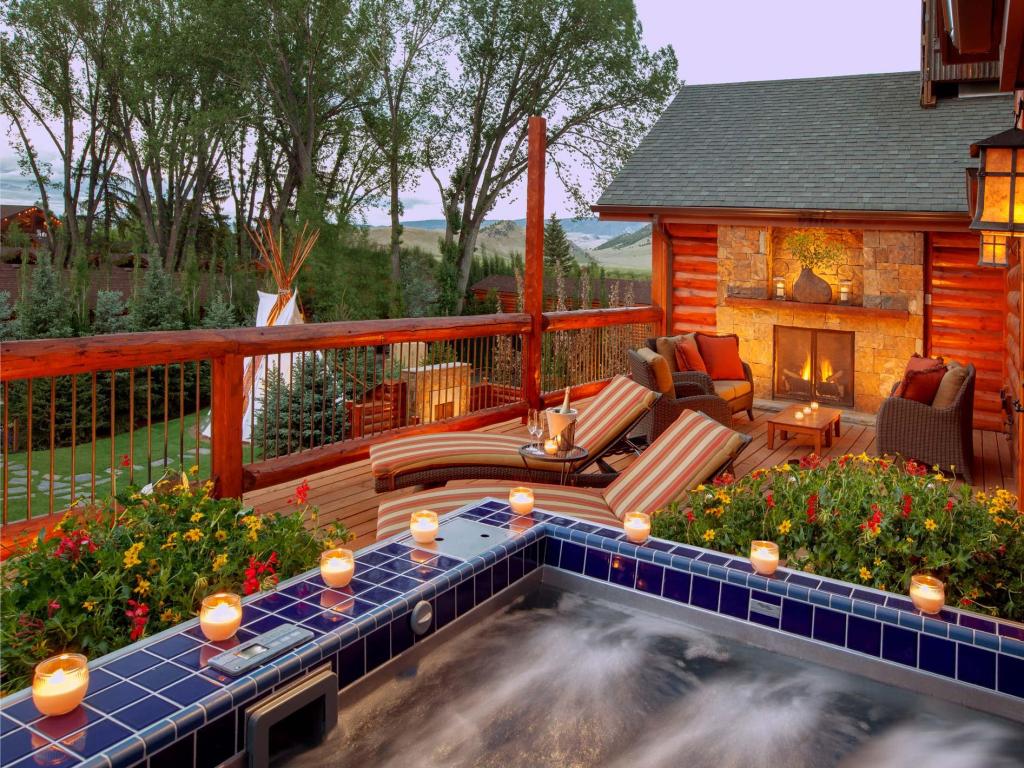 Luxury Grand Balcony Spa Suite at Rustic Inn Creekside, with candlelight around hot tub and loungers along terrace