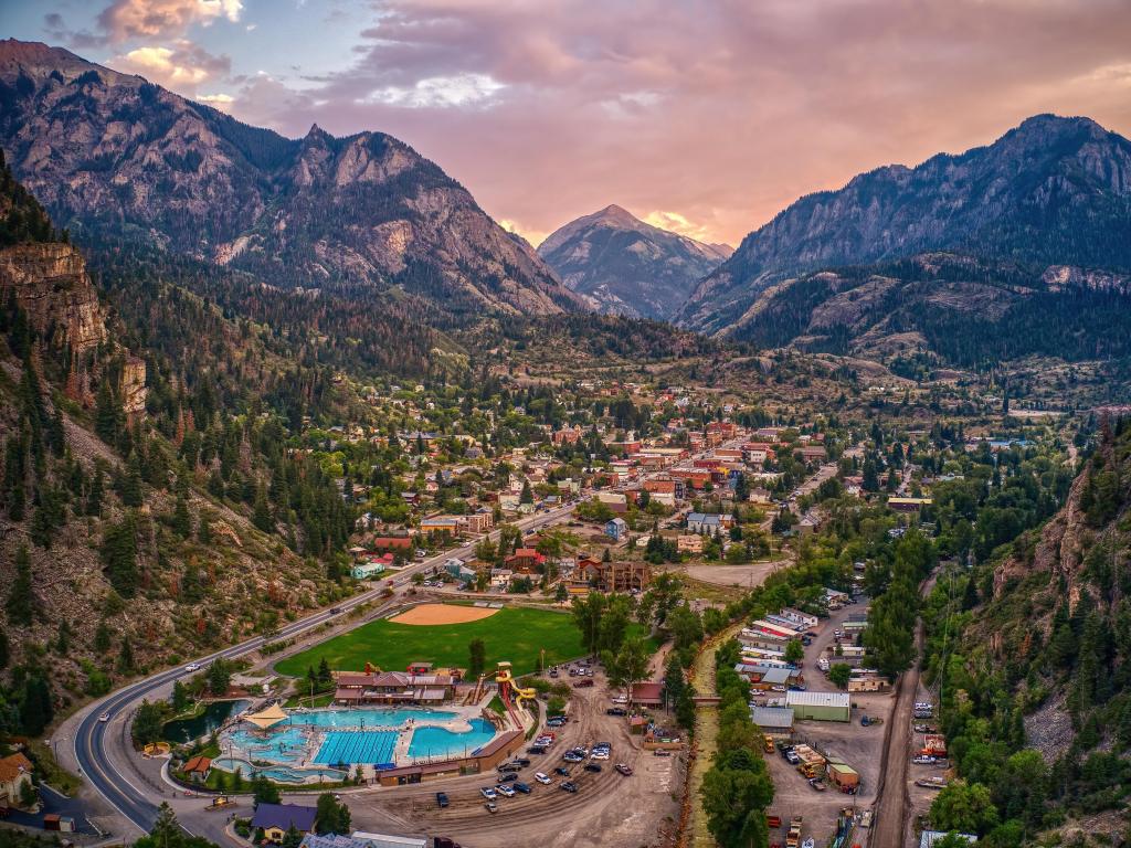 View of the city and hot spring pools with the backdrop of Rocky Mountains during sunset