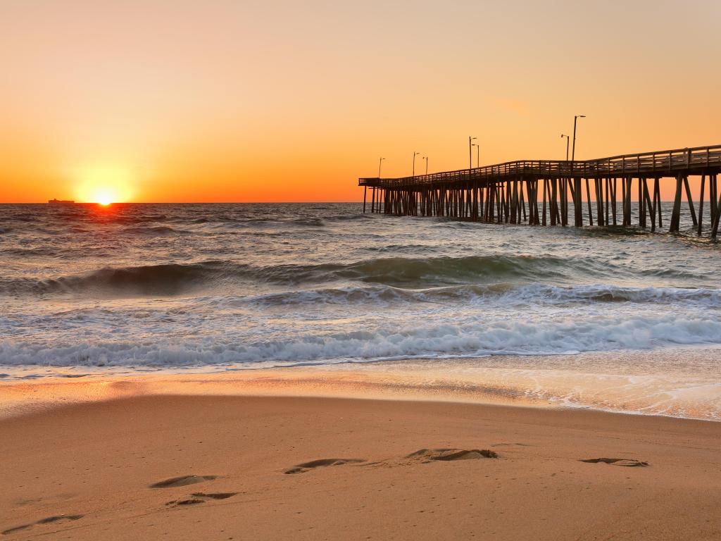 Fishing Pier at Sunrise at Virginia Beach, Virginia, USA. Virginia Beach, a coastal city in southeastern Virginia, lies where the Chesapeake Bay meets the Atlantic Ocean.