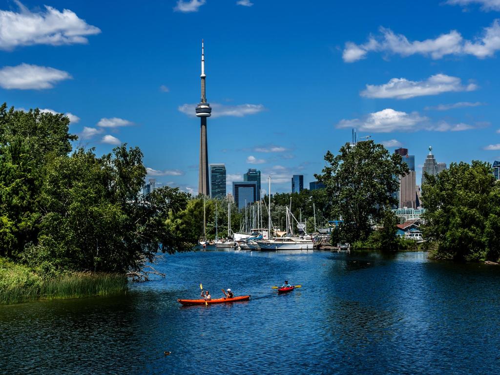 People kayaking on a sunny day with a view of Toronto near the Toronto Islands