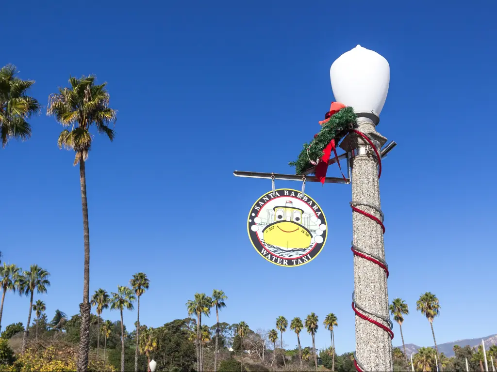 Santa Barbara water taxi sign decorated for Christmas with blue sky in the background