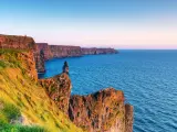 A view out towards the jagged cliffs at the Cliffs of Moher, Ireland, at sunset