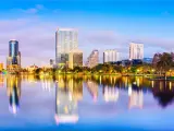 Orlando skyline at dusk with purple sky and buildings reflecting in Lake Eola in the foreground