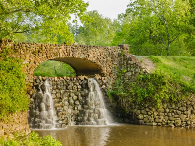 Waterfall Bridge at Reynolda Gardens with beautiful lush trees and plants surrounding it