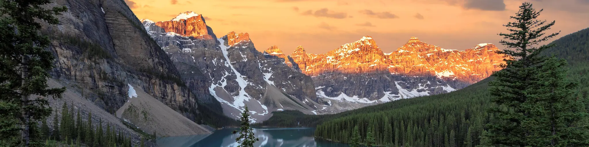 Dramatic sunrise at the Moraine lake in Banff National Park, snow capped mountains in the background