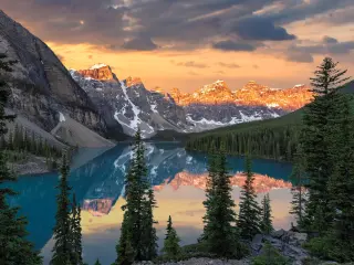 Dramatic sunrise at the Moraine lake in Banff National Park, snow capped mountains in the background