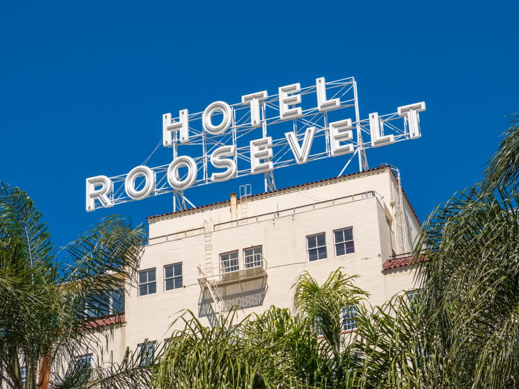 The white hotel sign on top of the flat roof, on a sunny day