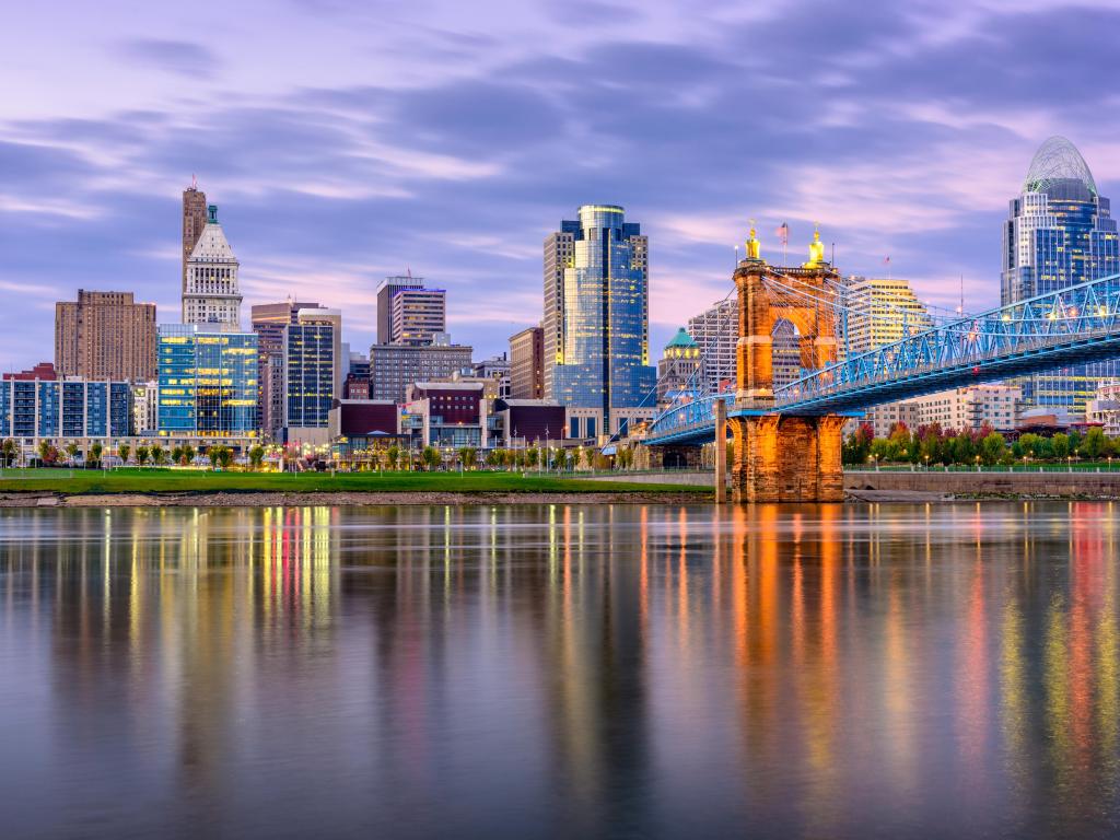 Cincinnati, Ohio, USA downtown skyline and bridge on the river at dusk.