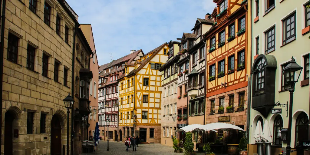 A view down Weißgerbergasse in Nuremberg with colourful timber framed houses either side and a cafe in the foreground