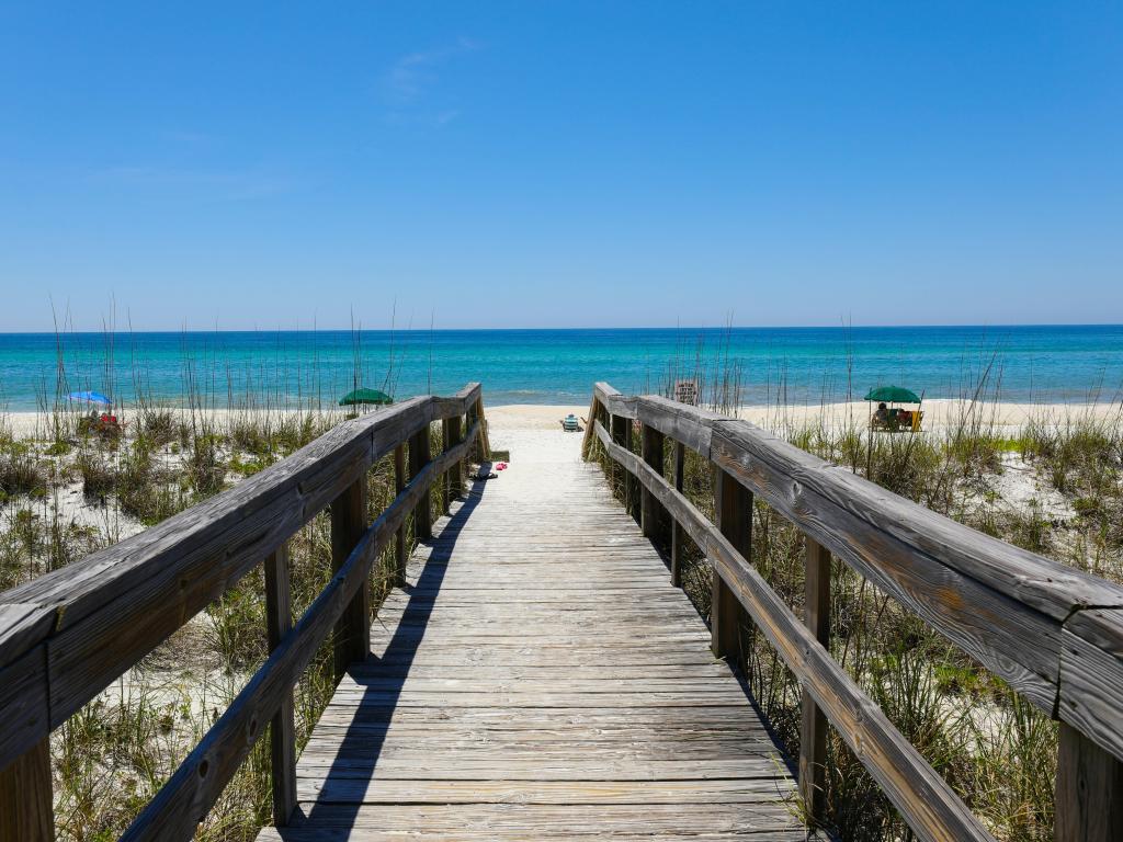 Wooden path crossing over dunes to reach quiet, sandy beach at Henderson Beach State Park, Destin, Florida