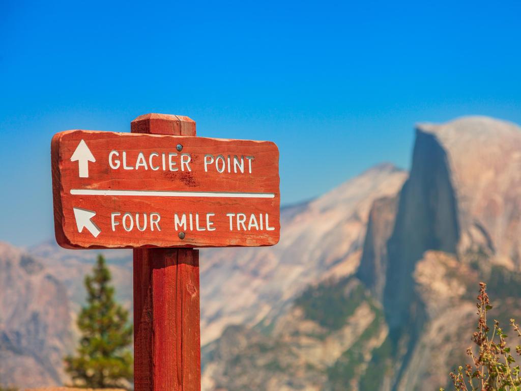 Wooden road sign marking Glacier Point trail and Four-Mile Trail in Yosemite National Park